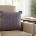 Cushion KULURI 50x50 in shades of purple with a colorful pattern and palette.